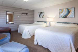 2 beds in 2 bedroom suite and sitting chairs at Welsh's Motel in Wall, SD