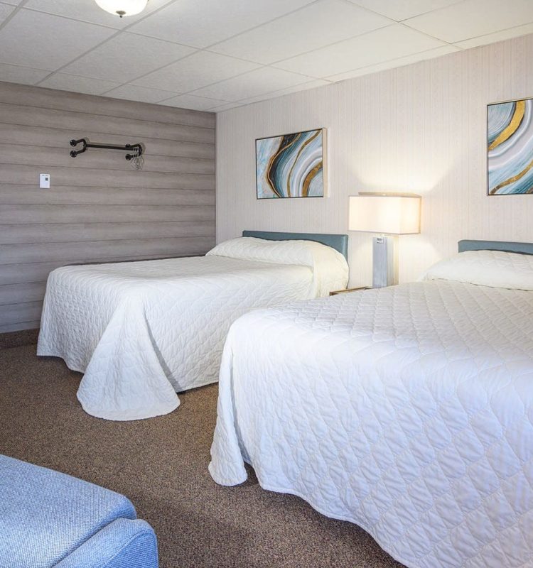 2 beds in 2 bedroom suite and sitting chairs at Welsh's Motel in Wall, SD