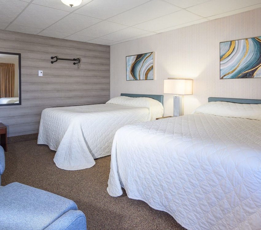 2 beds in 2 bedroom suite and sitting chairs at Welsh's Motel in Wall, SD