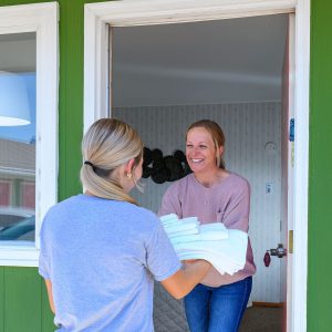 Smiling Welsh's Motel employee handing guest folded towels