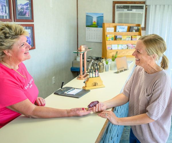 Smiling guest receiving key to room at Welsh’s Motel in Wall, SD Smiling guest receiving key to room at Welsh's Motel in Wall, SD