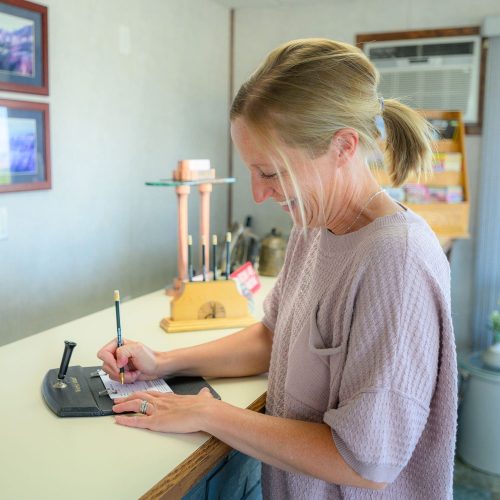 Smiling woman filling out form in the lobby of Welsh's Motel